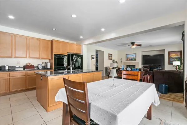 a kitchen with stainless steel appliances granite countertop a sink counter space cabinets and a view of living room