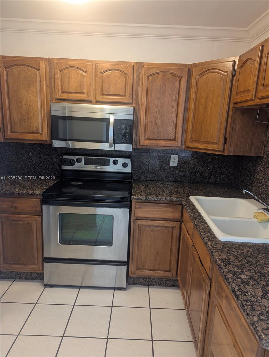 1051 Southwest 1st Street, Unit 411 Miami, FL 33130 - Photo 2 of 8 a kitchen with granite countertop a sink stove and cabinets