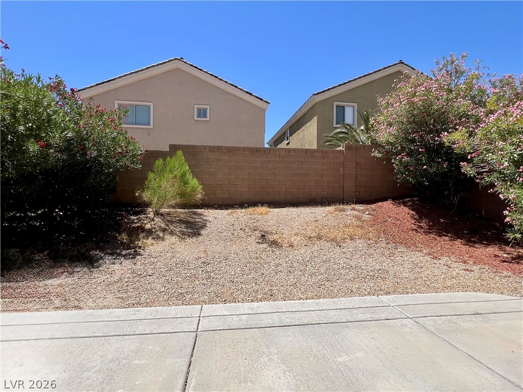 151 Short Ruff Way Las Vegas, NV 89148 - Photo 14 of 17 A block wall privacy fence borders the gravel yard framed by desert landscaping.