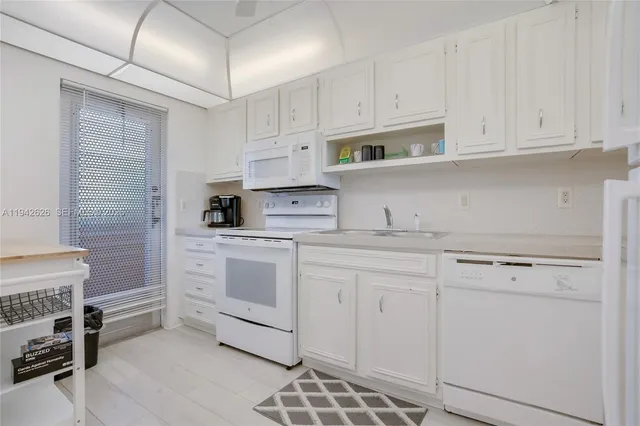 a kitchen with white cabinets and white appliances