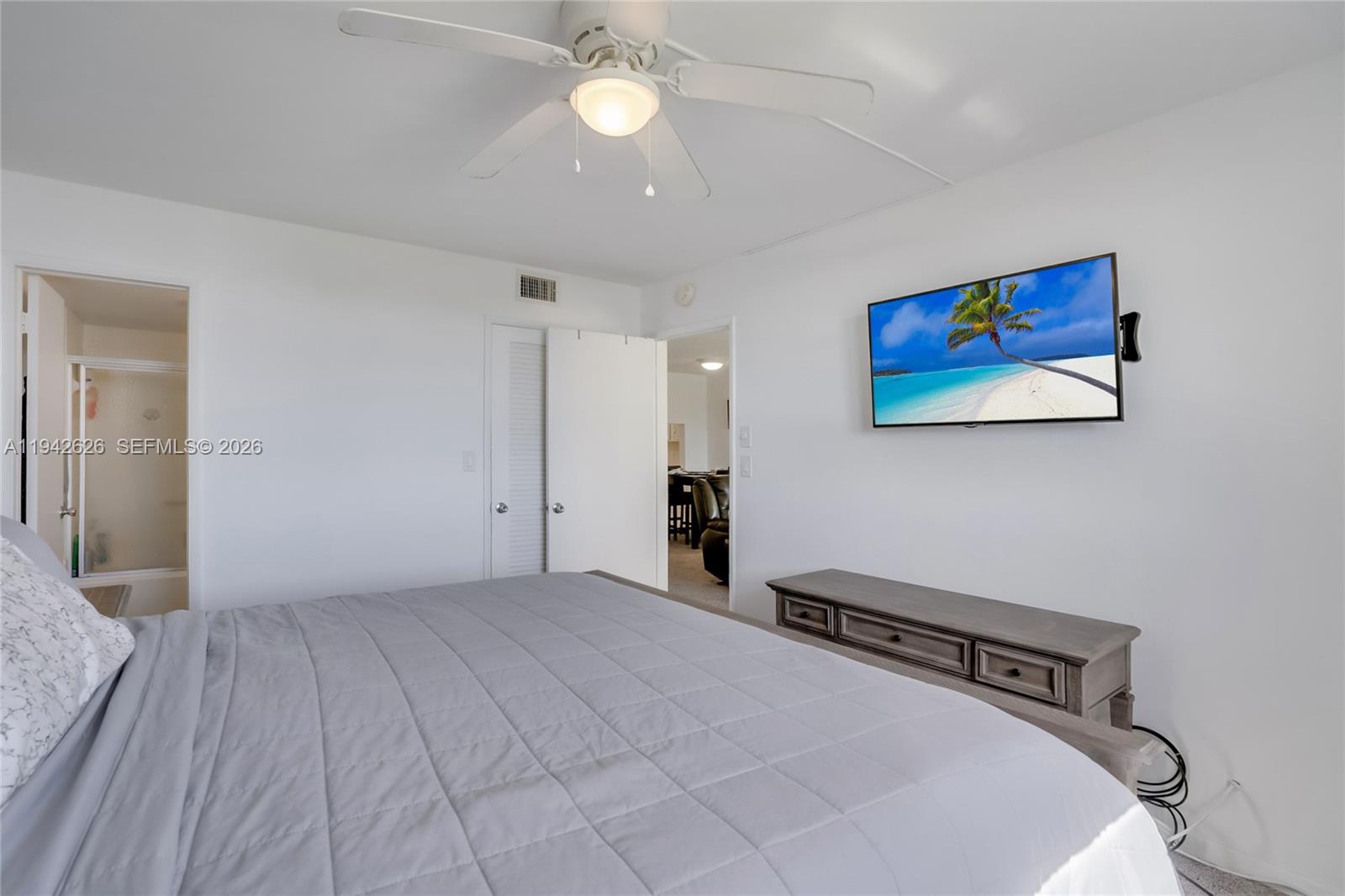 4502 North Federal Highway, Unit 334D Lighthouse Point, FL 33064 - Photo 10 of 15 a bedroom with a bed and a chandelier