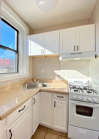 a kitchen with granite countertop white cabinets and white appliances