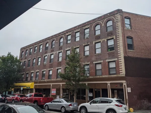 a front view of building with cars parked