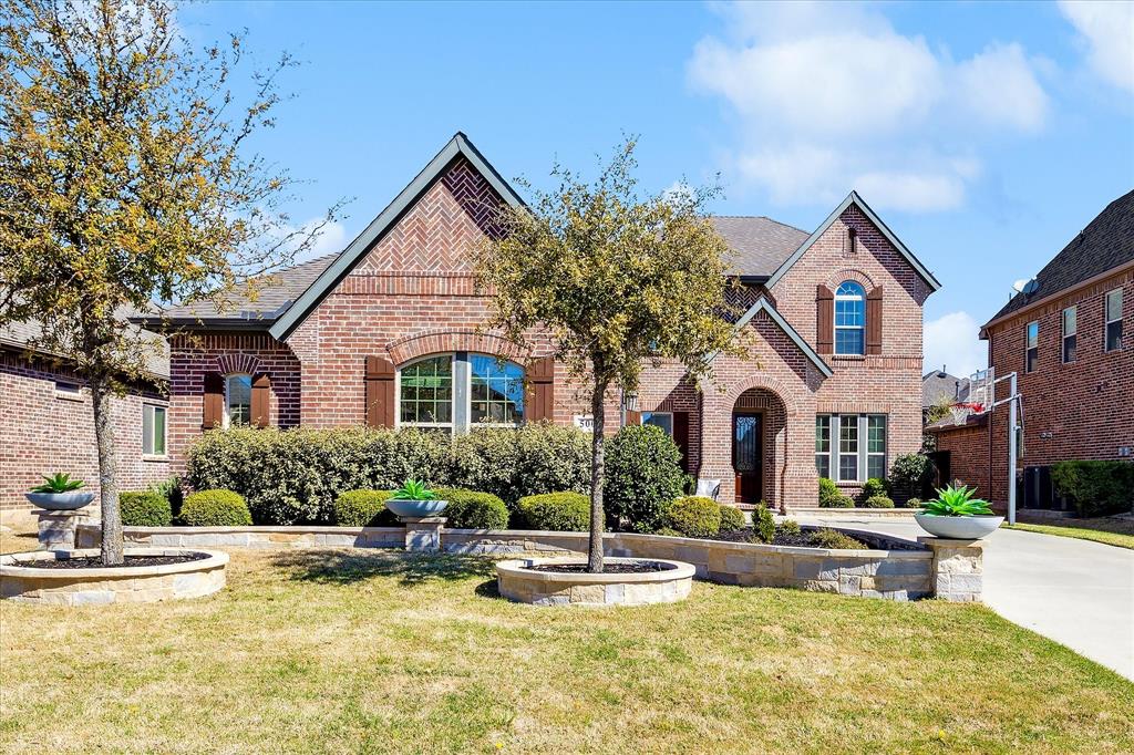 View of front of property with a front lawn, a 40 years shingled roof, and brick siding