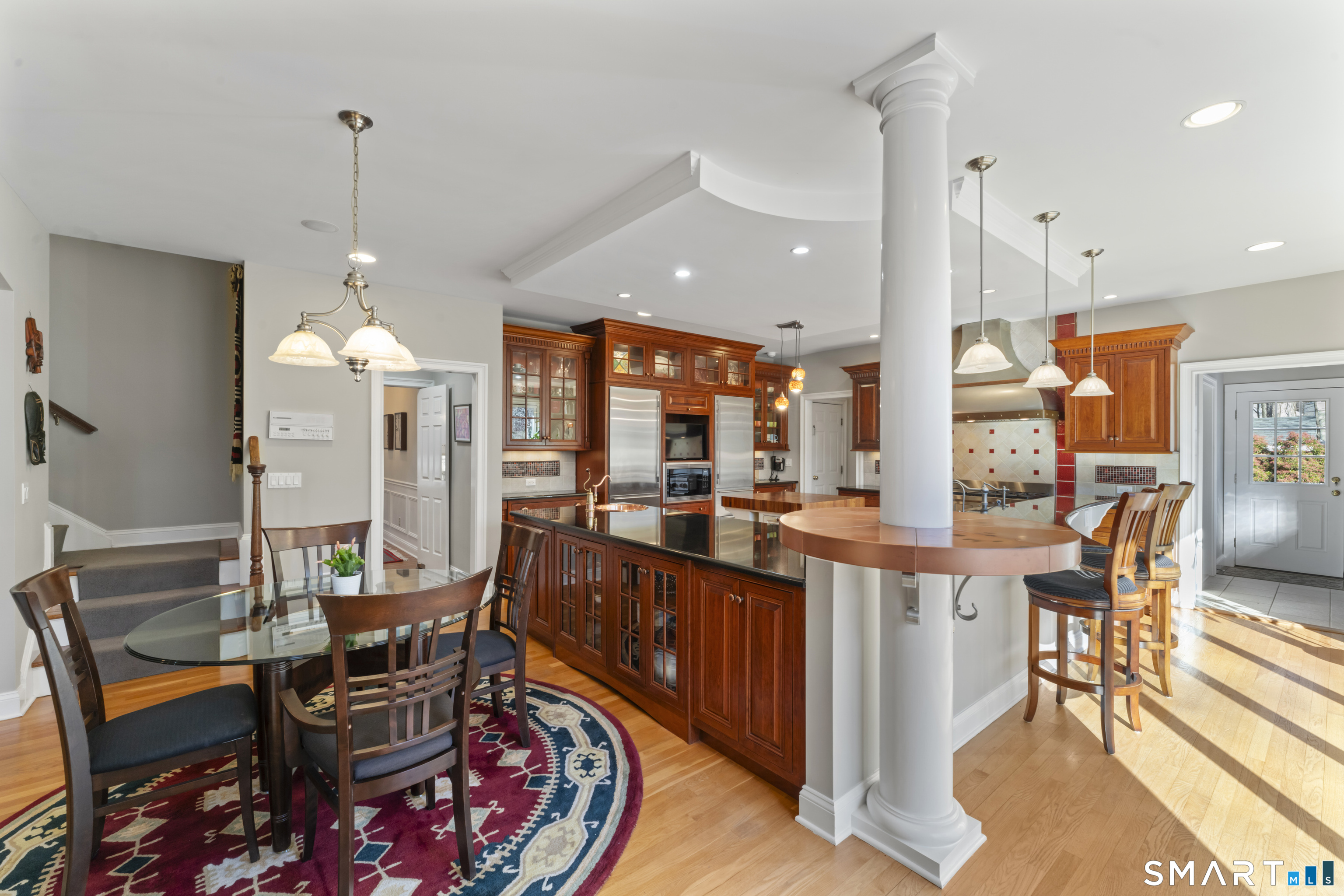 8 Cornerstone Court Ridgefield, CT 06877 - Photo 13 of 40 a kitchen with stainless steel appliances kitchen island granite countertop a table chairs and a view of living room