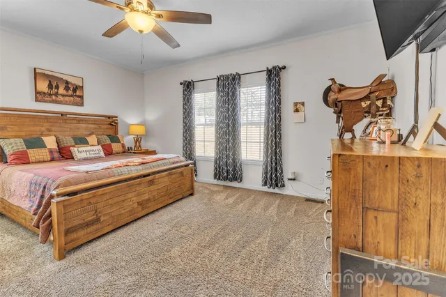 a spacious bedroom with a bed and a chandelier