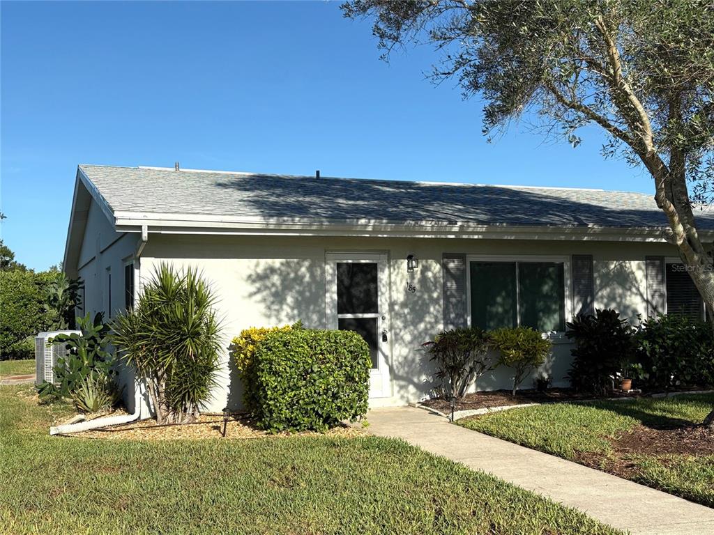 a view of a house with potted plants and large trees