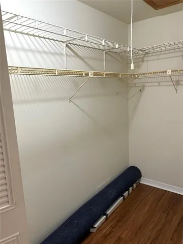 a view of a hallway with wooden floor and a window