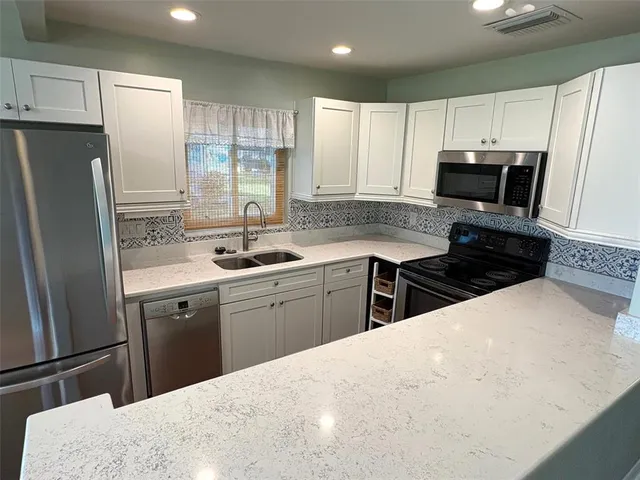 a kitchen with granite countertop a stove microwave and cabinets
