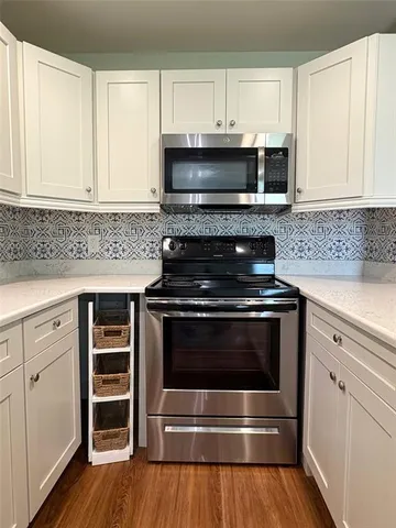 a kitchen with stainless steel appliances granite countertop a stove a sink and a microwave