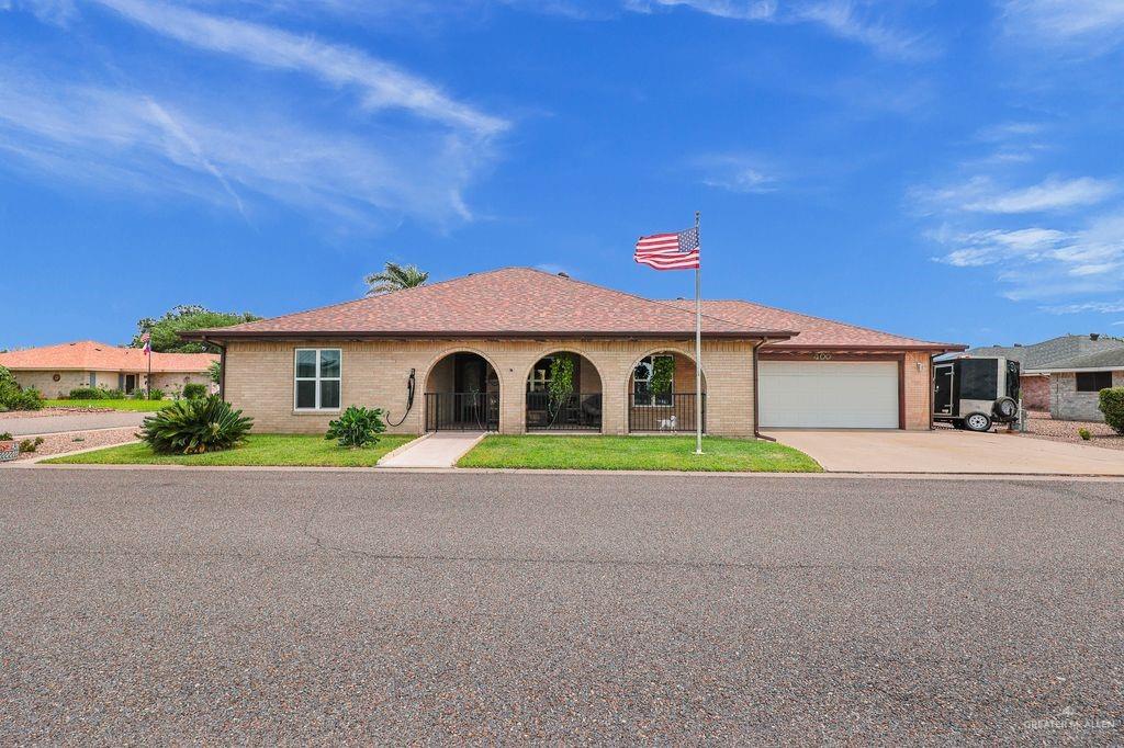 400 Taurus Street Mission, TX 78572 - Photo 1 of 16 View of front of house featuring driveway, an attached garage, brick siding, and a shingled roof