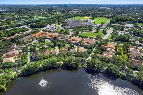 an aerial view of residential houses with outdoor space and trees