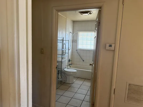 a bathroom with a granite countertop toilet a sink and a mirror