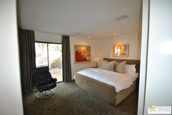 a spacious bedroom with a bed and glass window