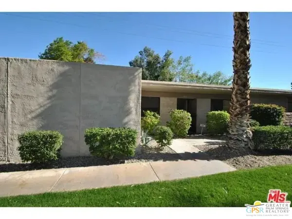 a view of a house with a yard and potted plants
