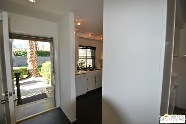 a view of hallway with bathroom and wooden floor