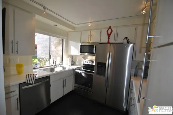 a kitchen with stainless steel appliances granite countertop a refrigerator and a sink