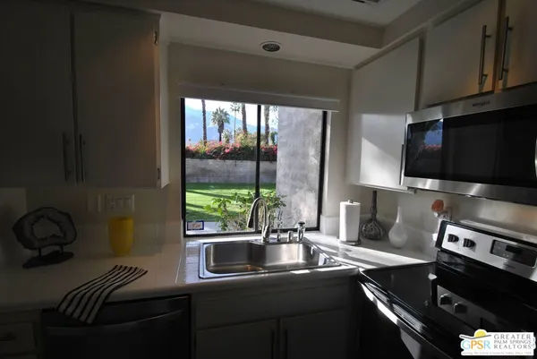 a kitchen with a sink appliances and a window