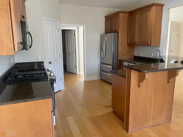 a kitchen with stainless steel appliances a refrigerator a stove and a sink
