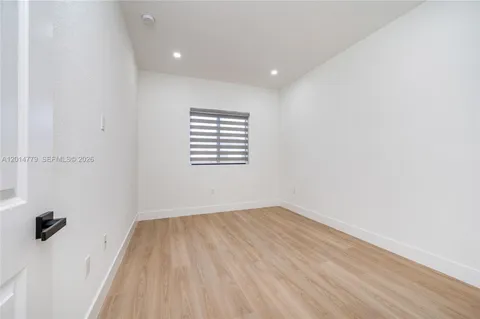 a view of a room with wooden floor and a window