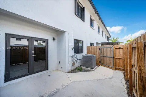 a backyard of a house with outdoor seating and barbeque oven