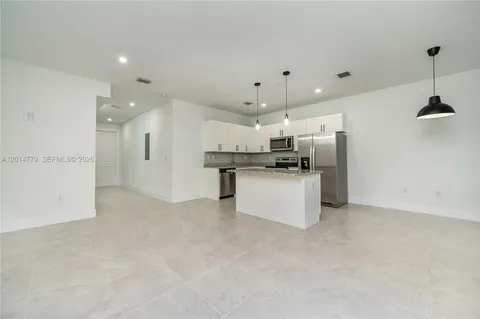 a kitchen with stainless steel appliances kitchen island a refrigerator sink and cabinets