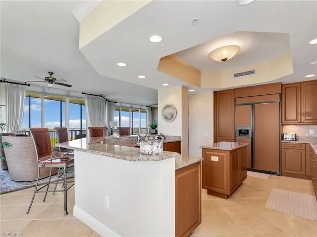 a view of a dining room with furniture a kitchen and chandelier