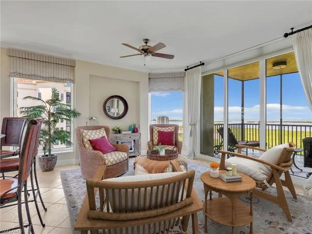 a living room with furniture a rug and a large window
