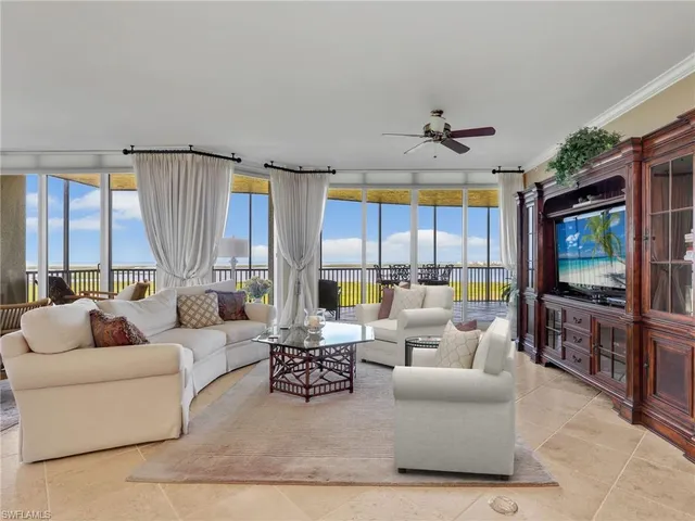 a living room with furniture a flat screen tv and a large window