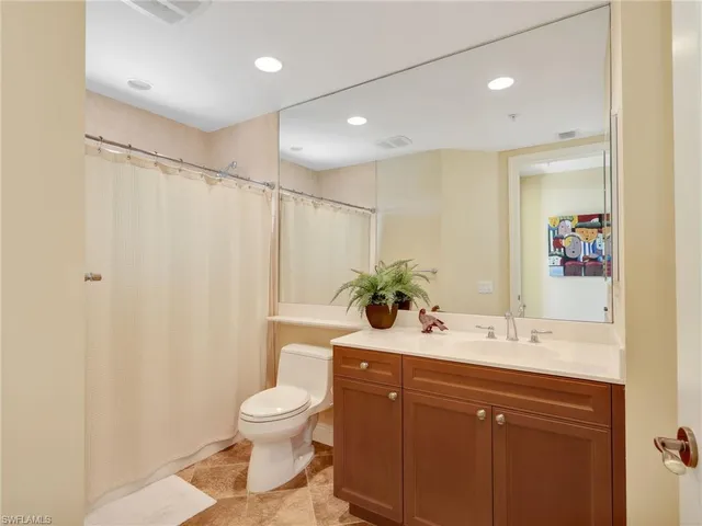 a bathroom with a granite countertop sink toilet a large mirror and shower