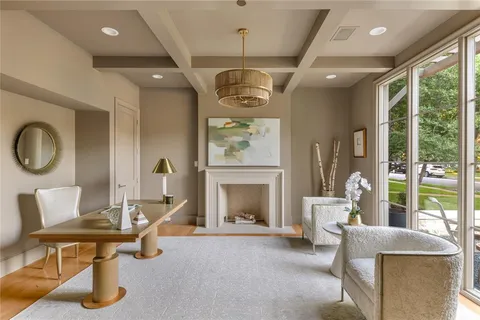 a living room with furniture a fireplace and a floor to ceiling window