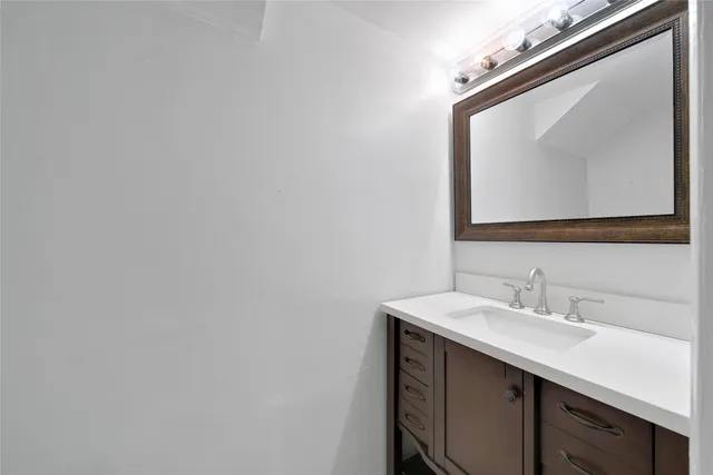 a bathroom with a sink vanity and a mirror