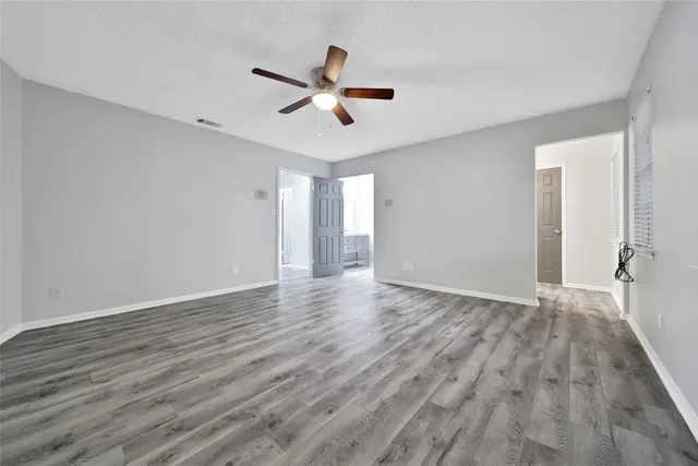 a view of empty room with wooden floor and window