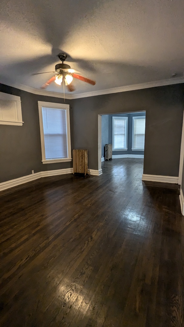 7249 South Princeton Avenue Chicago, IL 60621 - Photo 3 of 14 a view of an empty room with wooden floor and a window