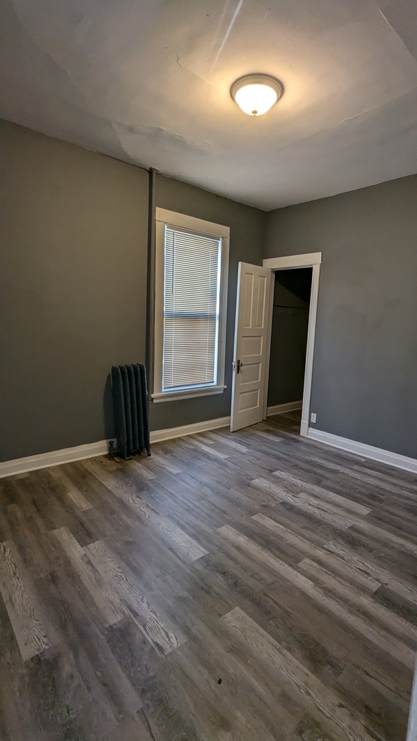 7249 South Princeton Avenue Chicago, IL 60621 - Photo 8 of 14 an empty room with wooden floor and windows