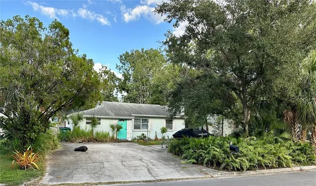 a backyard of a house with a table and chairs under an umbrella