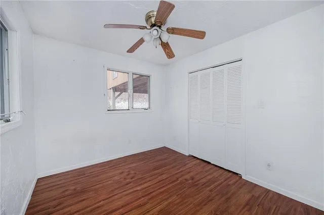 a view of room with a ceiling fan and wooden floor