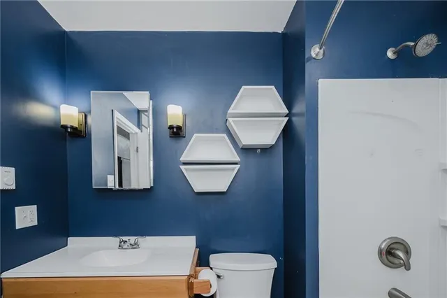 a bathroom with a toilet a sink and mirror