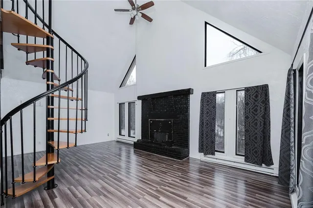 a view of a livingroom with wooden floor and staircase