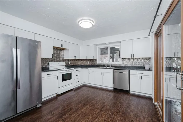 a kitchen with a white cabinets and wooden floor