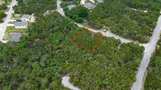 an aerial view of residential houses with outdoor space and trees