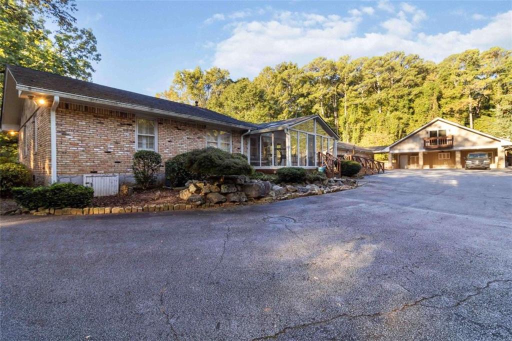 5888 Old Stone Mountain Road Stone Mountain, GA 30087 - Photo 27 of 61 a backyard of a house with table and chairs under an umbrella