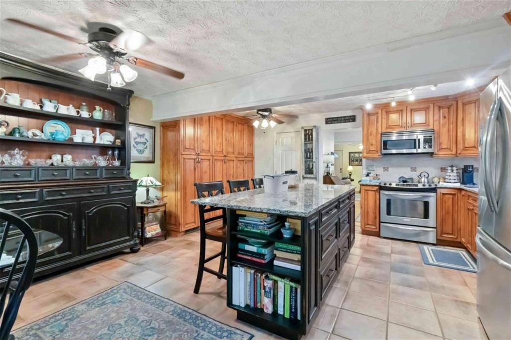 5888 Old Stone Mountain Road Stone Mountain, GA 30087 - Photo 46 of 61 a kitchen with a stove a sink a dining table and chairs