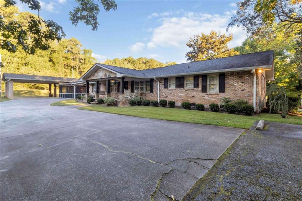 5888 Old Stone Mountain Road Stone Mountain, GA 30087 - Photo 6 of 61 a front view of a house with a garden and trees