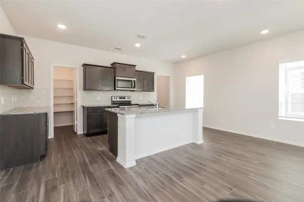 a kitchen with stainless steel appliances a refrigerator and a stove top oven