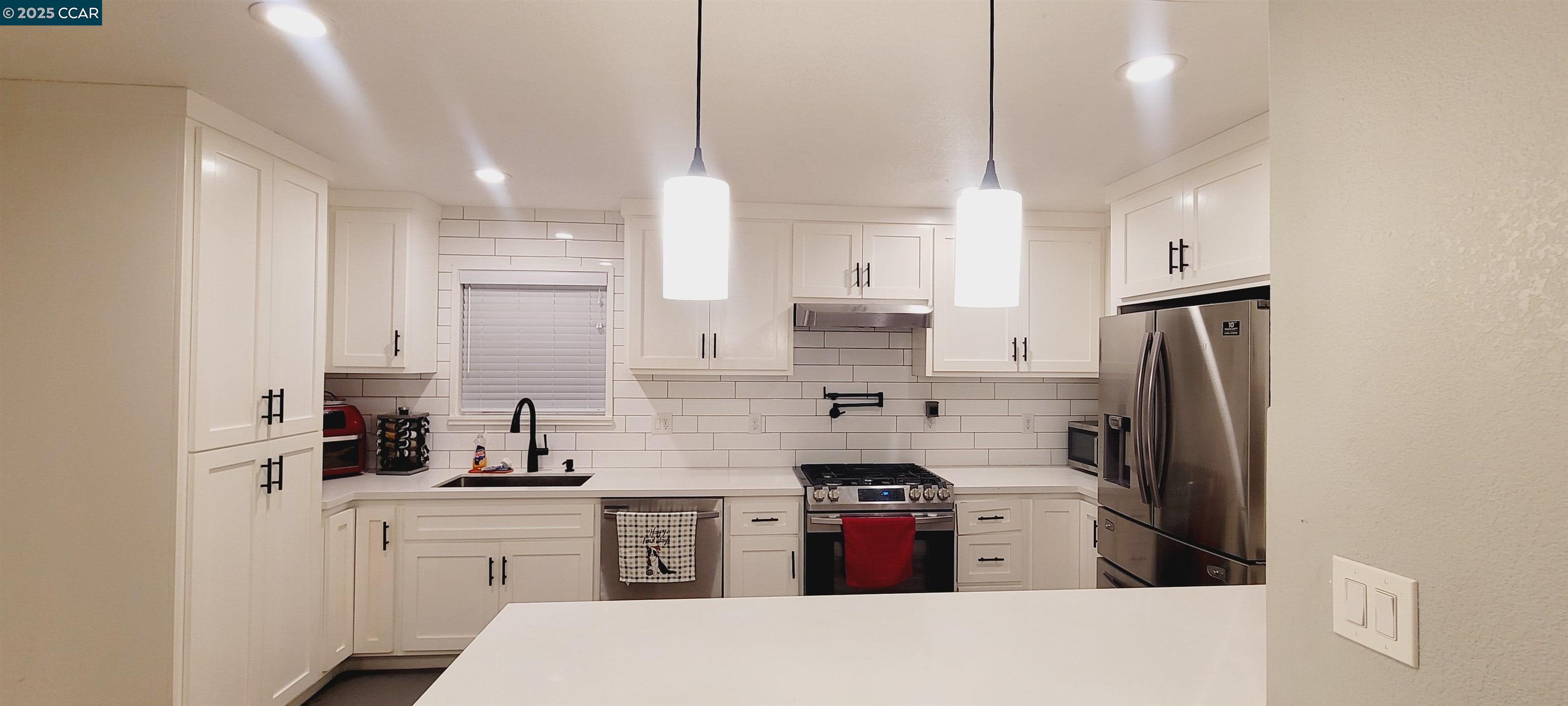 2744 El Rey Street Antioch, CA 94509 - Photo 6 of 23 a kitchen with stainless steel appliances kitchen island granite countertop a refrigerator a sink a stove and white cabinets