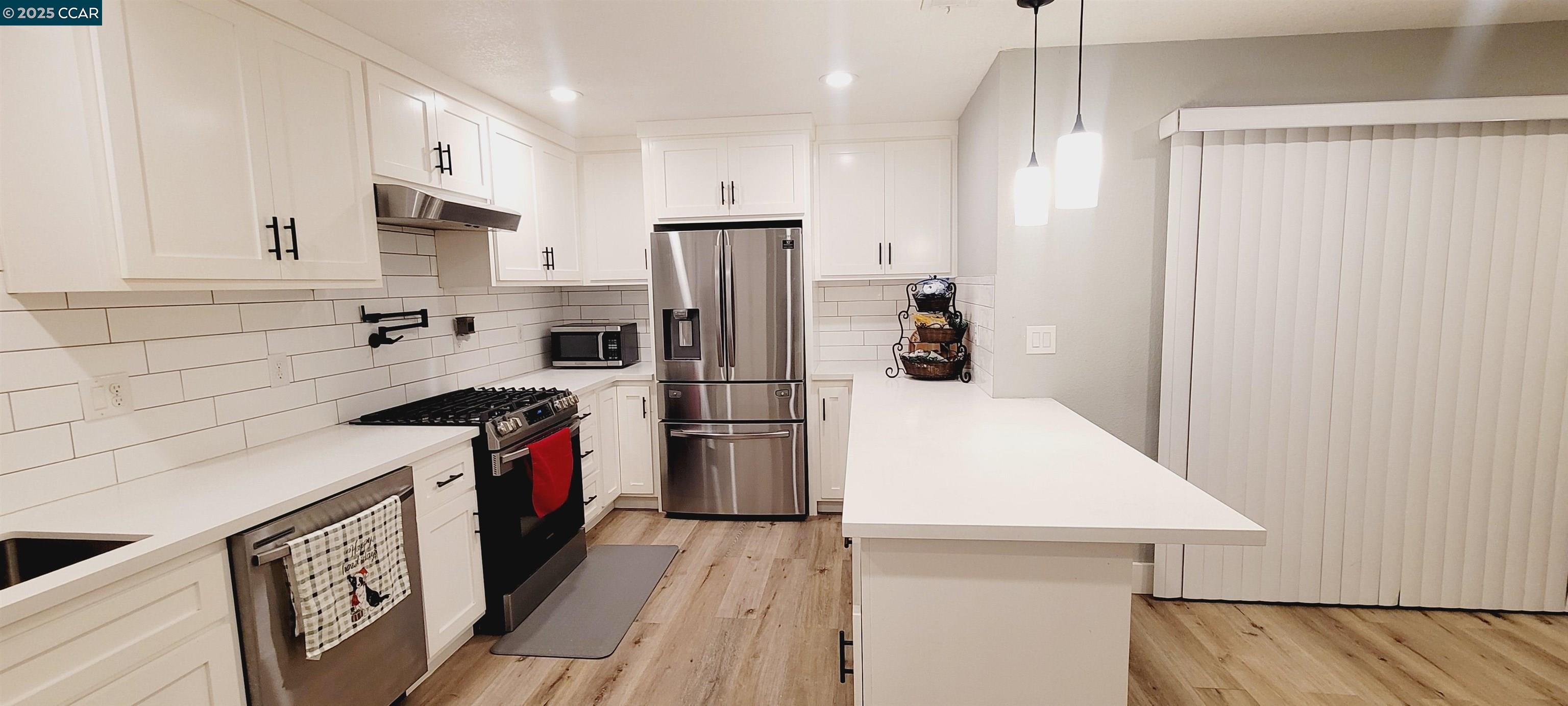 2744 El Rey Street Antioch, CA 94509 - Photo 9 of 23 a kitchen with a refrigerator a sink and wooden floor