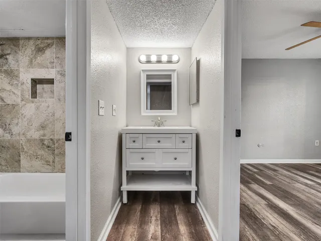 a bathroom with a tub sink and mirror