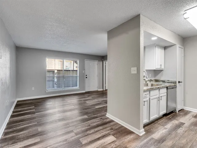 a view of kitchen with granite countertop cabinets and sink