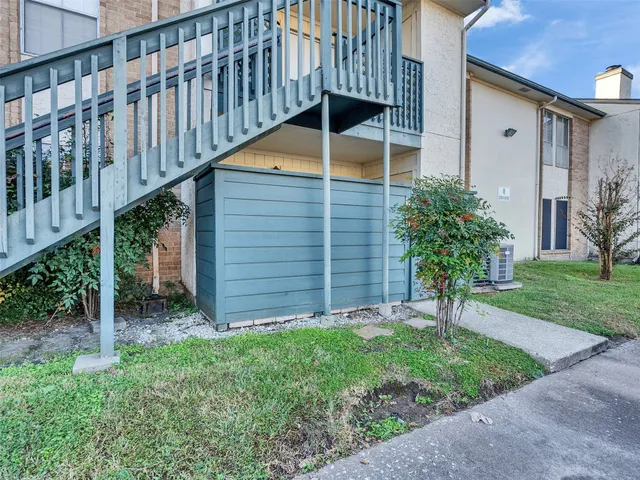 a backyard of a house with plants and wooden fence